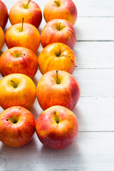 apple fruits in a row, white wooden table background