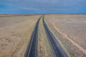Long straight road Route 66 interstate highway to left through the desert of New Mexico, US
