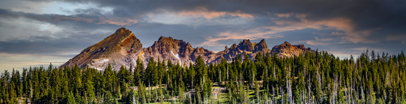 A panorama image of Broken Top mountain as it looms above Todd Lake in the late afternoon on a hot summer day, on Century Drive near Bend Oregon