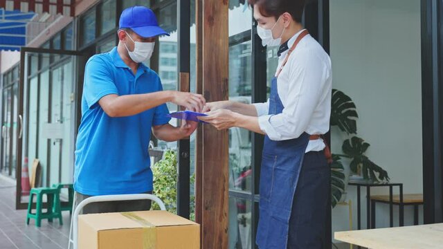 Asian Postman deliver food ingredient box to restaurant waiter in cafe