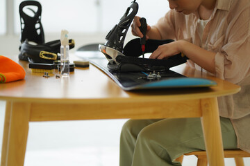 スノーボード板の手入れをする女性