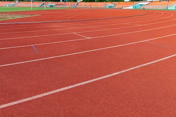 Fotobehang The curved lane in running track or athlete track in stadium. Running track is a rubberized artificial running surface for track and field athletics © torsakarin