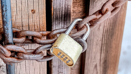 Pano Combination padlock and rusty iron chain securing the door of outdoor bathroom
