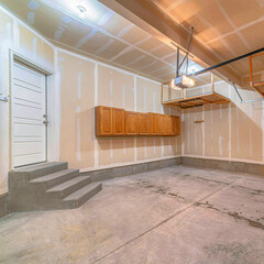 Square Residential garage interior under construction with unfinished wall and floor