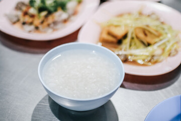 Boiled rice in blue bowl with food for eating which has chopstick. Street Chinese food.