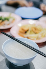 Boiled rice in blue bowl with food for eating which has chopstick. Street Chinese food.
