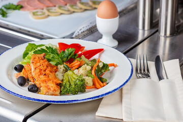 Fried vegetables on a plate. Boiled egg on a stand.