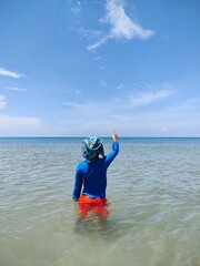 The boy in the sea with blue sky