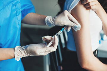 Close up photo of the vaccination process. Woman is vaccinated with serum from coronavirus.