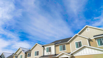 Pano Townhouses on a residential neighborhood landscape with cloudy sky background