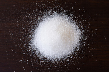 Obraz na płótnie Canvas Pile of white sand sugar isolated on dark background. Overhead view. Flat lay. 