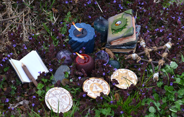 Magic ritual with pentagram, witch decorated book of spells and burning candles outside.