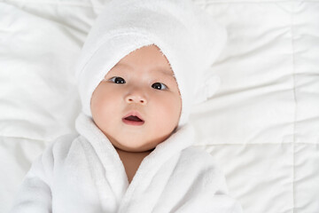 Fototapeta na wymiar close up baby in soft bathrobe on bed