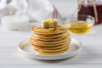 Honey sauce pours over a stack of pancakes. Breakfast concept.
