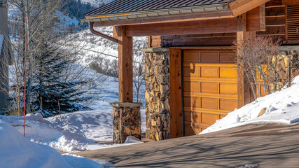 Pano Home exterior in Park City Utah against blue sky and snow dusted hill in winter