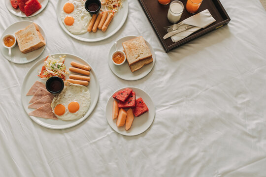 Hotel Complimentary Breakfast Sets Served On White Bed.