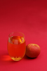 A glass of apple juice with fresh apple.