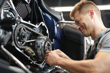Fototapeta na wymiar Male mechanik repair motorcycle in special service portrait.