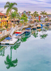Fototapeta na wymiar Vertical The beautiful canal in Long Beach California with boats and reflection of trees