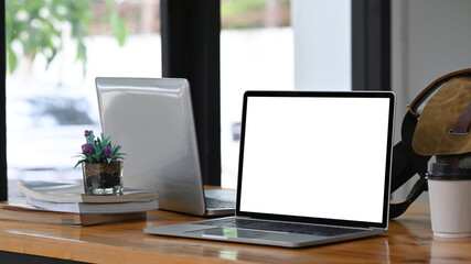 Mock up laptop computer, coffee cup and books on wooden table.