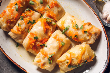 Plate with tasty stuffed cabbage rolls on grey background