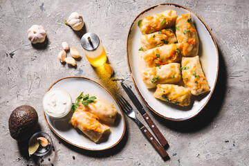 Plates with tasty stuffed cabbage rolls on grey background