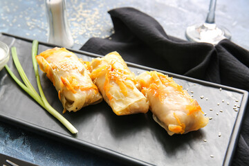Board with tasty stuffed cabbage rolls on table