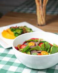 Salad with beef and strawberries in a white bowl. Meat and vegetables salad for lunch or dinner, healthy eating.
