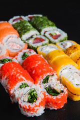 Sushi Set nigiri and sushi rolls served on black stone background. Japanese cuisine concept