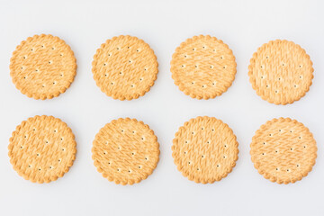 Round cookie white background top view. Eight light yellow crackers lie in two rows. A food texture with space for text. Creative cooking template. Unsweetened wheat biscuits. Crunchy breakfast