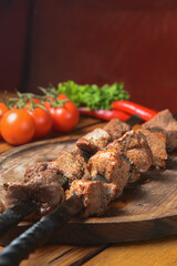 Marinated shashlik cooked on a barbecue grill over charcoal. Shashlik or Shish kebab served on a wooden board