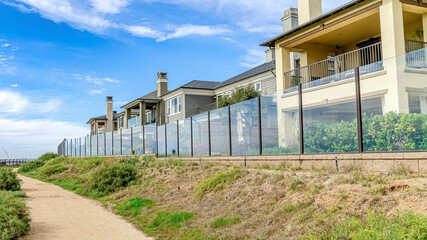 Fototapeta na wymiar Pano Houses overlooking a pathway with view of the sea in Huntington Beach California