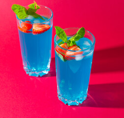 blue lagoon cocktail drink with strawberries and mint leaves