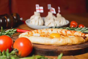 Beautiful open pies khachapuri with egg and onions on wooden background.