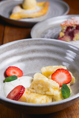 Vanilla cream dessert with sour cream and fresh organic strawberry. Served in a traditional bowl.