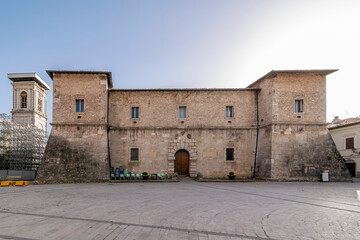 Fototapeta premium The facade of the ancient La Castellina palace and the bell tower of the cathedral, Norcia, Italy