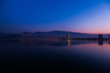 Fototapeta na wymiar View of the city of Izmir, Turkey. Panorama of Izmir after sunset at golden hour from the sea.