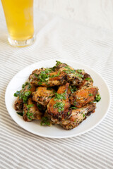 Homemade baked Garlic Parmesan Chicken Wings with Cold Beer, low angle view.