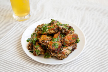 Homemade baked Garlic Parmesan Chicken Wings with Cold Beer, side view.