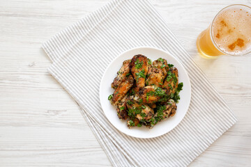 Homemade baked Garlic Parmesan Chicken Wings with Cold Beer, top view. Flat lay, overhead, from above. Space for text.