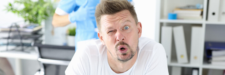 Obraz premium Surprised man undergoes medical examination by proctologist