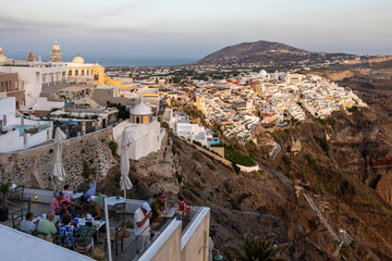 Fototapeta premium The whitewashed town of Fira in warm rays of sunset on Santorini island, Cyclades, Greece