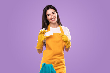 Smiling woman in apron and gloves showing blank business card