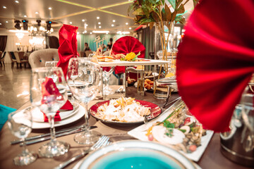 a table in a restaurant on a holiday with bright red napkins