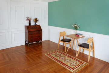 테이불과 의자, 그리고 그린벽과 우드 바닥이 있는 리빙룸