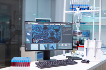Computer with microbiology virus expertise on display standing on table during medicine...