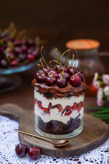 Chocolate dessert with cherries and whipped cream served in a large glass. Black Forest pie in an unusual interpretation