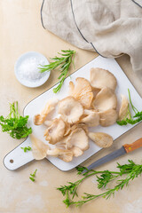 Organic oyster mushrooms with herbs and salt on cutting board