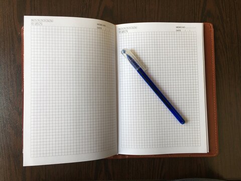 notebook and pen, note and blue pen on wooden table