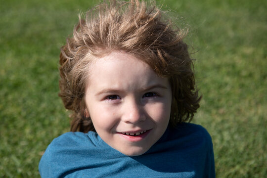 Kids portrait, close up cute child on grass in park.